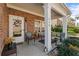 Charming front porch with brick facade, welcome decor, and seating area at 230 Rosenwald Ln, Hampton, GA 30228