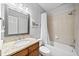 Bathroom with granite vanity, framed mirror, combination tub and shower, and tan tiled walls at 302 Meadow Lark Xing, Canton, GA 30114