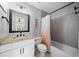 Bathroom featuring a vanity with a granite countertop, large mirror, tub/shower combo and neutral tile at 302 Meadow Lark Xing, Canton, GA 30114