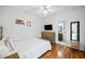 Cozy bedroom with hardwood floors, ceiling fan, dresser, TV, and doorway to a full bathroom at 302 Meadow Lark Xing, Canton, GA 30114