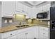 Bright kitchenette featuring white cabinets, granite countertops, tile backsplash, and undermount microwave at 302 Meadow Lark Xing, Canton, GA 30114