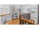 Second floor landing with hardwood floors, iron railings, pendant lighting, and multiple doorways at 302 Meadow Lark Xing, Canton, GA 30114