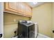 Functional laundry room with upper cabinets and modern washer and dryer at 302 Meadow Lark Xing, Canton, GA 30114