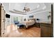Bright main bedroom with tray ceiling, hardwood floors, ceiling fan, and a bay window with seating at 302 Meadow Lark Xing, Canton, GA 30114