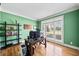 Green office with a large window, desk, bookcase, and hardwood floors at 302 Meadow Lark Xing, Canton, GA 30114
