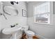 Bright powder room with pedestal sink, toilet, wainscoting, and natural light at 302 Meadow Lark Xing, Canton, GA 30114