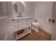 Modern powder room with white vanity, round mirror and wood-look floors offers a clean, contemporary design at 3020 Templeton Ln, Loganville, GA 30052