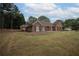 Red brick home with mature trees and a well-maintained lawn at 3020 Templeton Ln, Loganville, GA 30052