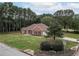 Red brick home with manicured lawn, mature trees, and a neighborhood street view at 3020 Templeton Ln, Loganville, GA 30052