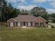 Charming single-story red brick home featuring black shutters, well-manicured lawn, and mature trees at 3020 Templeton Ln, Loganville, GA 30052