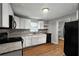 Kitchen featuring white cabinets, black appliances, wood-look floors and granite countertops at 1090 Harwell Nw St, Atlanta, GA 30314