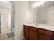 Bright bathroom featuring a vanity with cabinets and a large mirror over the sink at 1917 Baxley Pine Trce, Suwanee, GA 30024