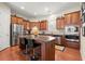 A well-equipped kitchen with stainless steel appliances, granite countertops, kitchen island with seating, and wood cabinets at 1917 Baxley Pine Trce, Suwanee, GA 30024