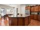 Kitchen with granite island and seating, stainless steel appliances and wooden cabinets, with dining area in background at 1917 Baxley Pine Trce, Suwanee, GA 30024