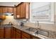 Granite countertops compliment this kitchen, paired with stainless steel sink, tile backsplash and hardwood cabinets at 1917 Baxley Pine Trce, Suwanee, GA 30024