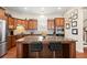A kitchen with wood cabinets, stainless steel appliances, large granite island with seating, and hardwood floors at 1917 Baxley Pine Trce, Suwanee, GA 30024