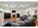 Comfortable living room with a fireplace, media cabinets, a large leather sectional, and open floorplan at 1917 Baxley Pine Trce, Suwanee, GA 30024