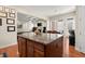 Open floor plan view of kitchen island, dining area, and living room complete with fireplace and mounted TV at 1917 Baxley Pine Trce, Suwanee, GA 30024
