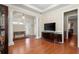 Bright living room with hardwood floors, tall pillars, and a large television at 1917 Baxley Pine Trce, Suwanee, GA 30024