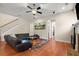 Open-concept living room with hardwood floors, a black leather sofa, and bright natural light at 1917 Baxley Pine Trce, Suwanee, GA 30024