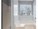 Bright bathroom featuring a large soaking tub with tiled surround and window view at 1979 Resting Creek Dr, Decatur, GA 30035