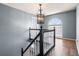 Well-lit staircase with wooden handrail, and decorative chandelier at 1979 Resting Creek Dr, Decatur, GA 30035