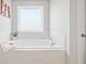 Large soaking tub with marble tile surround, and natural light at 273 Amylou Cir, Woodstock, GA 30188