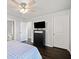 This bedroom features a ceiling fan and dark wood flooring, complemented by a large dresser with a TV at 273 Amylou Cir, Woodstock, GA 30188