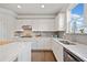 Bright kitchen features white cabinets, stone countertops and backsplash, and stainless steel appliances at 273 Amylou Cir, Woodstock, GA 30188