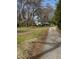 Charming single story home with a white exterior and black shutters surrounded by a lush green lawn and mature trees at 1027 N Born Rd, Stone Mountain, GA 30088