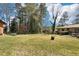 Spacious backyard featuring a brick home, mature trees, and lush green grass at 1254 Renee Dr, Decatur, GA 30035