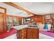 Open kitchen with a granite island, integrated cooktop, view of living area, and wood-paneled walls at 1254 Renee Dr, Decatur, GA 30035