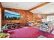 Living room features wood-paneled walls, a fireplace, and a large screen television at 1254 Renee Dr, Decatur, GA 30035