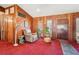 Spacious living room with wood paneled walls, neutral furniture, and bright red carpet at 1254 Renee Dr, Decatur, GA 30035