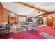 Living room open to kitchen with wood-paneled walls, vaulted ceilings, and brick fireplace at 1254 Renee Dr, Decatur, GA 30035