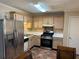 Cozy kitchen featuring stainless steel appliances, tile backsplash, and light wood cabinets at 1848 San Gabriel Ave, Decatur, GA 30032