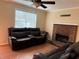 Cozy living room featuring a brick fireplace, ceiling fan, plush couches, and wood-look flooring at 1848 San Gabriel Ave, Decatur, GA 30032