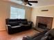 View of the living room showcasing a brick fireplace, ceiling fan, and window letting in natural light at 1848 San Gabriel Ave, Decatur, GA 30032