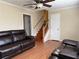 Cozy living room featuring hardwood floors, ceiling fan, and a comfortable brown leather sofa at 1848 San Gabriel Ave, Decatur, GA 30032