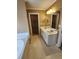 Bathroom with dual sinks, a large mirror, and a doorway leading to a walk-in closet at 210 Vintage Dr, Covington, GA 30014