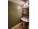 A well-lit half bathroom features a pedestal sink, decorative mirror, and modern lighting at 210 Vintage Dr, Covington, GA 30014