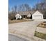 Ranch-style home with a two-car garage, driveway, and a yard with mature trees at 210 Vintage Dr, Covington, GA 30014