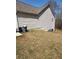Side yard of a home with vinyl siding, air conditioning units, and grassy area with sparse ground cover at 210 Vintage Dr, Covington, GA 30014