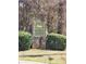 A stone community welcome sign reads 'The Woods of Dearing' surrounded by lush greenery at 210 Vintage Dr, Covington, GA 30014