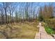 Landscaped backyard featuring a lush lawn, mature trees, and a dark wooden fence at 4740 Union Hill Rd, Canton, GA 30115