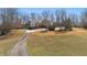 Eye-level view of a home on a manicured lawn, showcasing trees, a driveway, and lush landscaping at 4740 Union Hill Rd, Canton, GA 30115