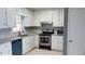 Galley kitchen featuring white cabinets, granite countertops, and stainless steel appliances at 1655 Cherry Hill Sw Rd, Conyers, GA 30094