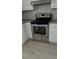 Stainless steel oven with white cabinets and gray backsplash at 1655 Cherry Hill Sw Rd, Conyers, GA 30094