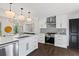 Bright, updated kitchen with white cabinets, stainless steel appliances, and designer lighting at 1970 Furlong Run, Lawrenceville, GA 30043