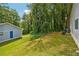 The backyard boasts a well-maintained lawn with lush greenery, a detached garage, and privacy at 2415 Wales Dr, Austell, GA 30106